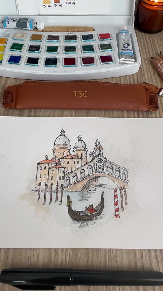 A watercolour palette next to a finished painting